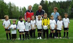 Freuen sich mit den Kindern: Trainer Thomas Köhler sowie die Sponsoren der Trikots Wilma und Wolfgang Kießling