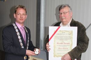 Bürgermeister Jürgen Hoffmann überreicht dem geehrten Berndt Amann Urkunde und Silbernen Ehrenring.